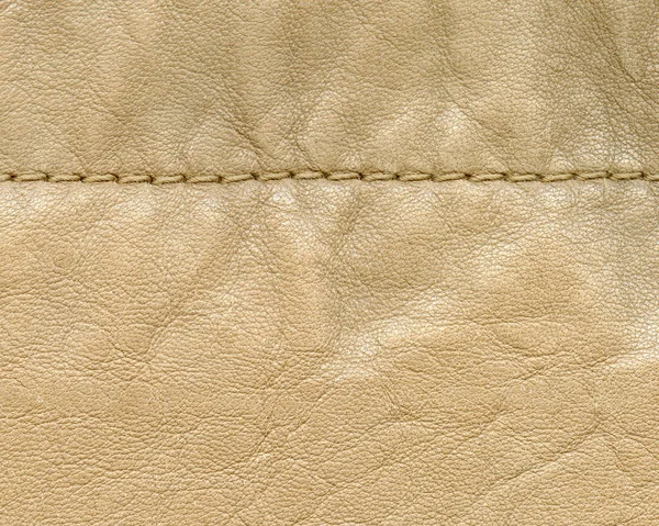 Beige leather background decorated with a seam — Stock Photo, Image