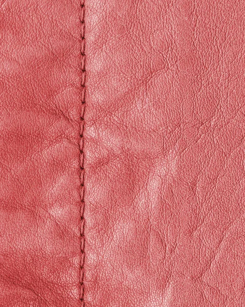Red leather background decorated with a seam — Stock Photo, Image