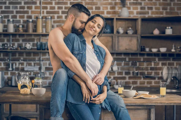Пара обіймається на кухні — стокове фото