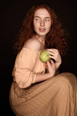 Kızıl saçlı kadın holding elma