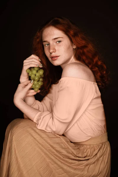 Рыжая женщина позирует с виноградом — стоковое фото