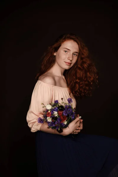 Kızıl saçlı kız holding kır çiçekleri — Stok fotoğraf