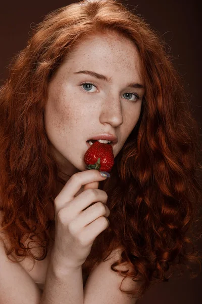 Rusovláska žena jíst jahody — Stock fotografie
