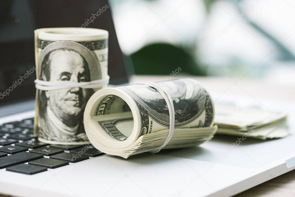 dollar banknotes on laptop