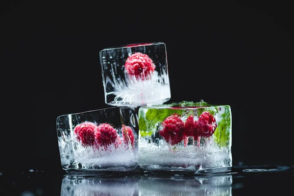 Framboesas congeladas em cubos de gelo — Fotografia de Stock