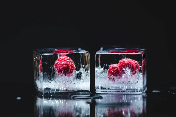 Raspberries frozen in ice cubes — Stock Photo, Image