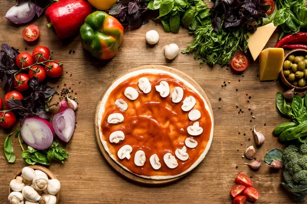 Pizza dough with tomato sauce and mushrooms — Stock Photo, Image
