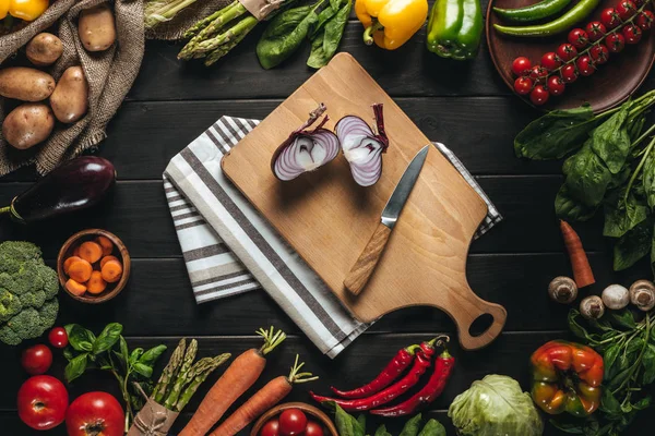 Placa de corte com cebola e faca — Fotografia de Stock