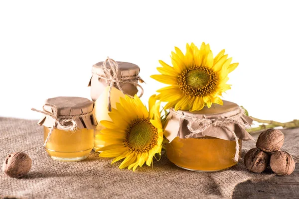 Подсолнухи и мед в стеклянных банках — стоковое фото