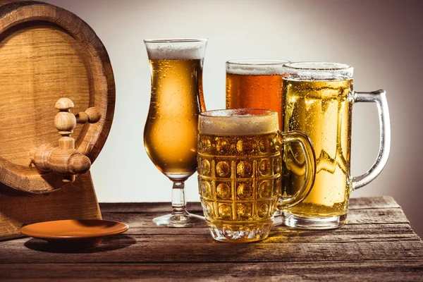 Бочка и разное пиво в стаканах — стоковое фото