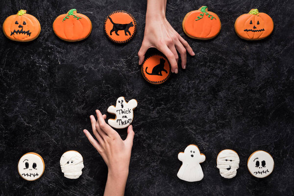 women holding homemade halloween cookies