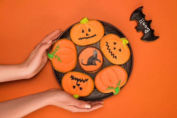 Mulher segurando placa de biscoitos halloween — Fotografia de Stock