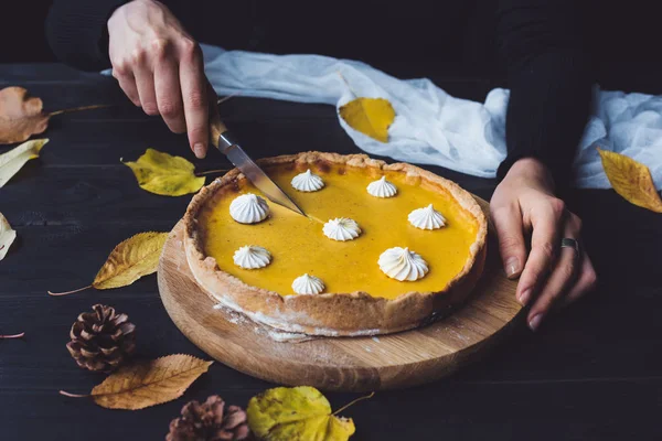 Weibliche Hände schneiden Kürbiskuchen — Stockfoto