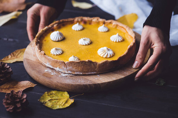 женские руки кладут пирог на стол
