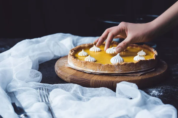 Vrouwelijke hand plaatsen van meringue op taart — Stockfoto