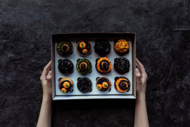 Cadılar Bayramı cupcakes holding eller