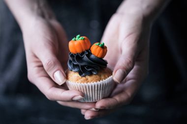 Cadılar Bayramı cupcake tutan kişi