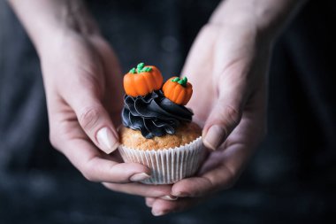 person holding halloween cupcake clipart