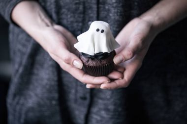 person holding halloween cupcake