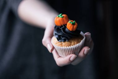 Cadılar Bayramı cupcake tutan kişi