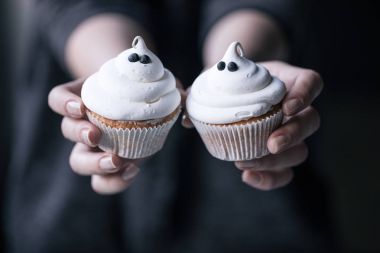 Cadılar Bayramı cupcakes tutan kişi