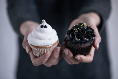 Cadılar Bayramı cupcakes tutan kişi