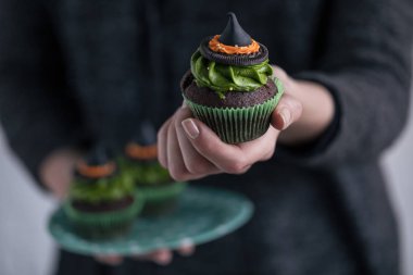 Cadılar Bayramı cupcake tutan kişi