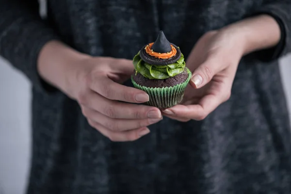 Person som innehar halloween cupcake — Stockfoto