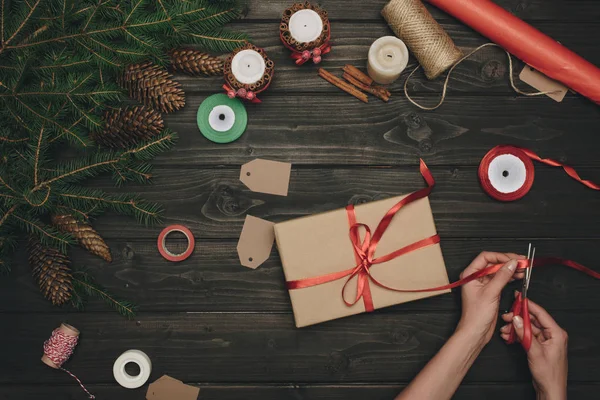 Woman decorating christmas gift — Stock Photo, Image