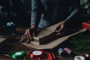 woman wrapping book as christmas gift clipart