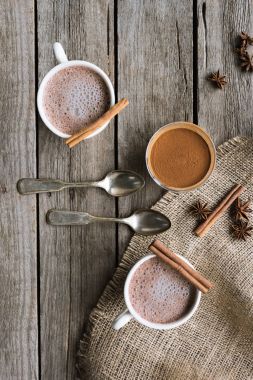 cups of cacao and spices on table clipart