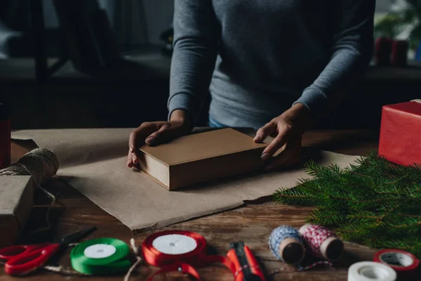 Woman wrapping book as christmas gift — Free Stock Photo