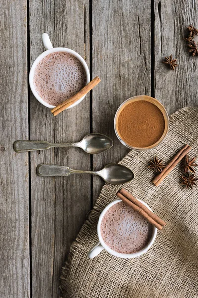 Cups of cacao and spices on table — Stock Photo, Image