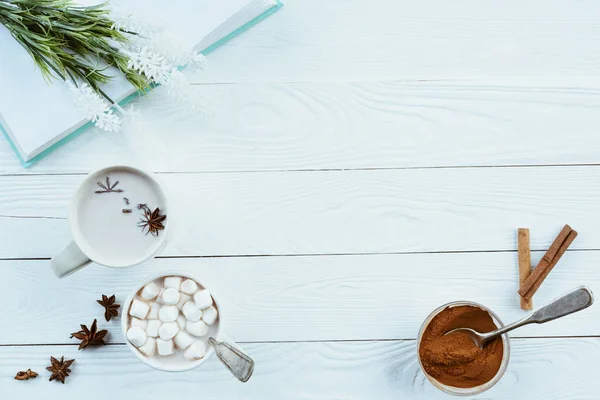 cups of aromatic cacao and book