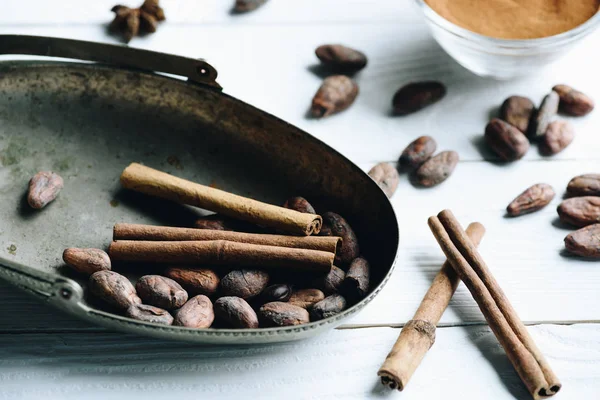 Cacao beans and cinnamon sticks — Stock Photo, Image