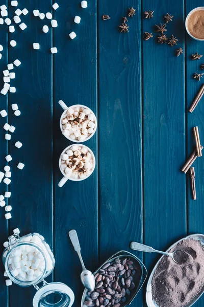 Cups of cacao drink and various spices — Stock Photo, Image