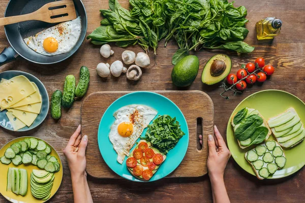 Woman holding cutting board with breakfast — Stock Photo, Image