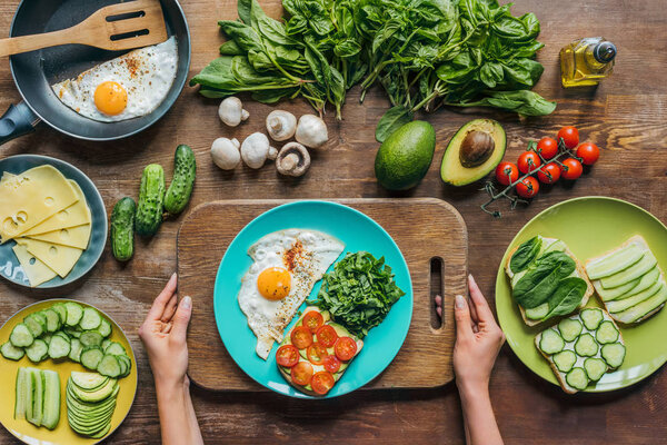 woman holding cutting board with breakfast