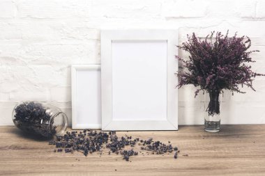 empty photo frames and flowers on table