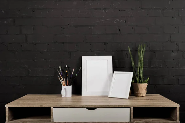 Photo frames and drawing equipment on table — Stock Photo, Image