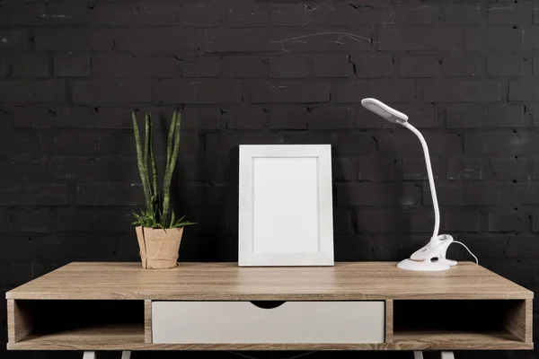 Foto rámeček a stolní lampa na pracovišti — Stock fotografie