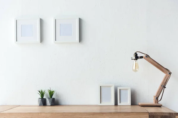 Photo frames hanging on wall at workplace — Stock Photo, Image