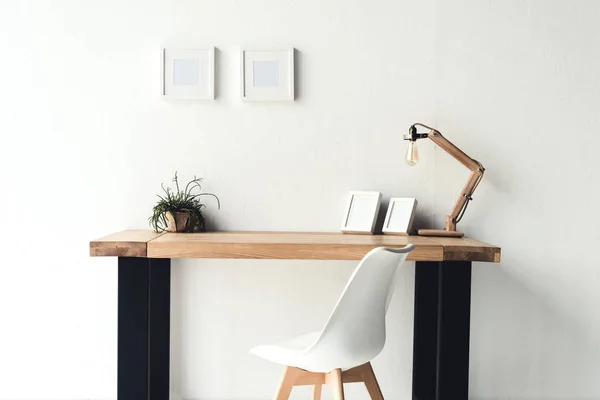 Photo frames hanging on wall at workplace — Stock Photo, Image