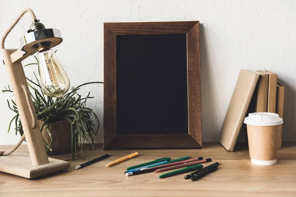 Marco de fotos y café para ir a la mesa — Foto de Stock