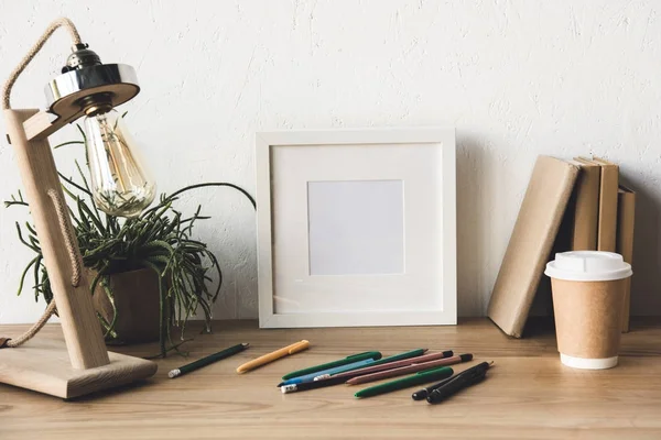 Moldura da foto e café para ir na mesa — Fotografia de Stock