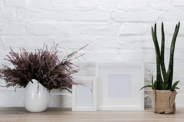 empty photo frames and flowers on tabletop