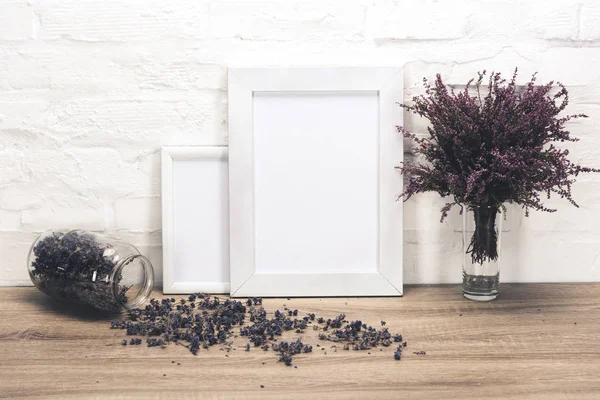 Empty photo frames and flowers on table — Stock Photo, Image