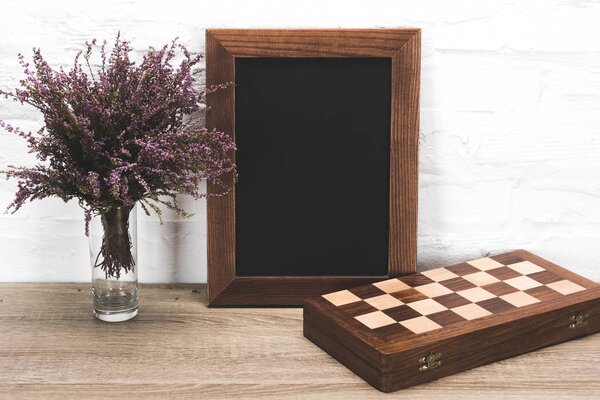 рамка для фото и шахматная доска на столе
