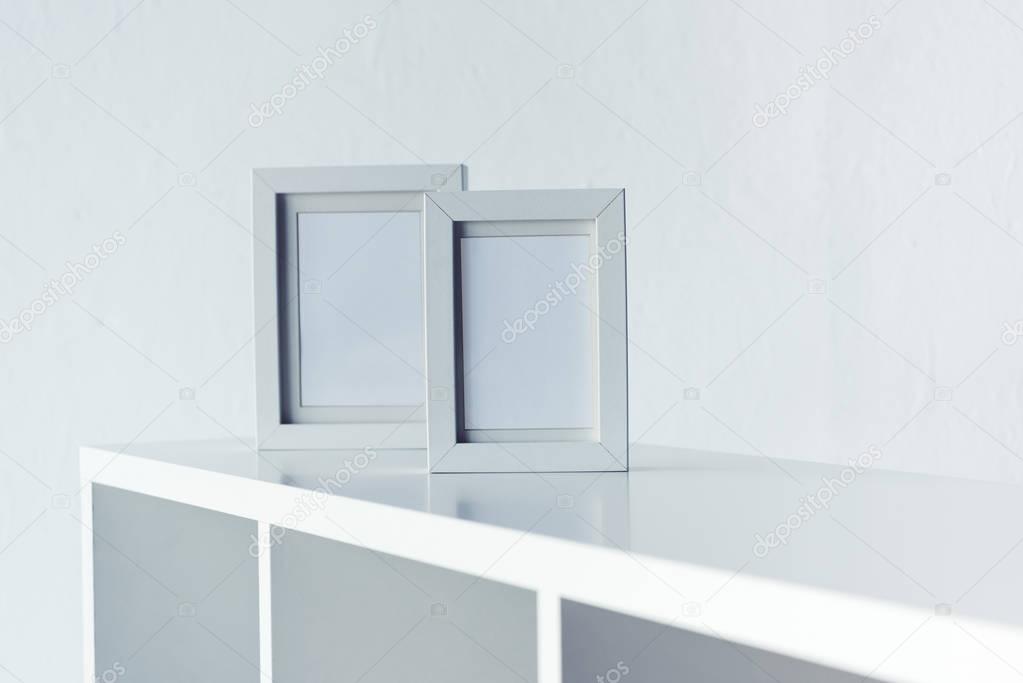 empty photo frames on bookshelf 
