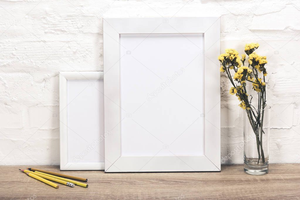 empty photo frames and flowers in vase